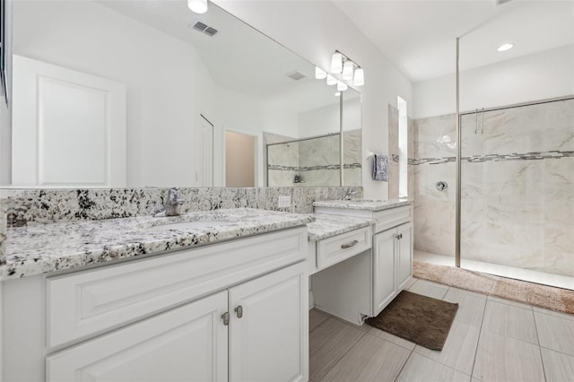 bathroom with visible vents, walk in shower, and vanity