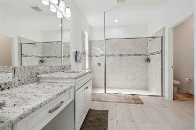 bathroom featuring visible vents, toilet, vanity, and a marble finish shower