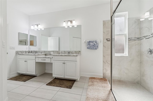 full bathroom featuring a walk in shower, double vanity, a sink, and baseboards