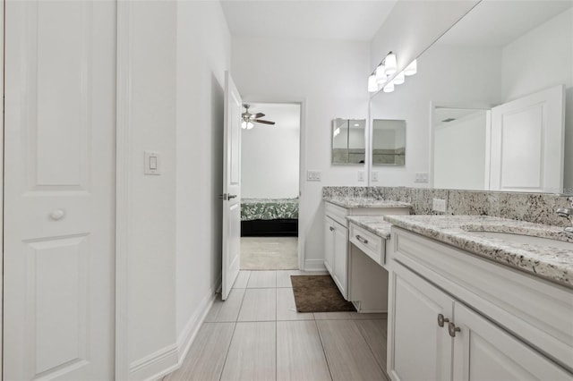 ensuite bathroom with baseboards, connected bathroom, vanity, and a ceiling fan