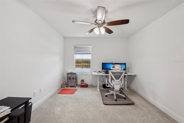 carpeted home office featuring baseboards and a ceiling fan