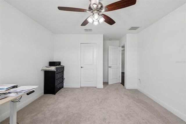 interior space featuring baseboards, visible vents, a ceiling fan, and light colored carpet