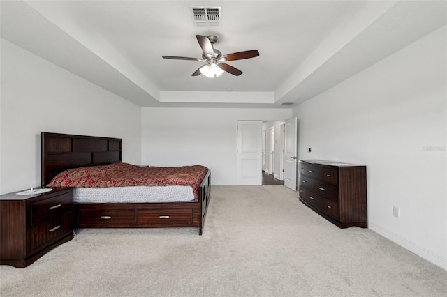 bedroom featuring ceiling fan, light carpet, visible vents, baseboards, and a raised ceiling