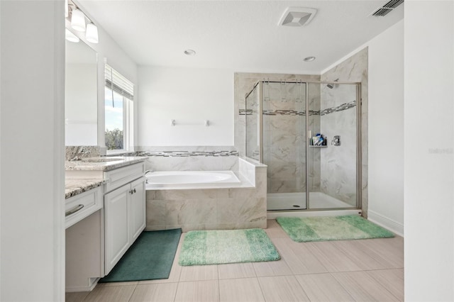 bathroom with visible vents, a garden tub, vanity, and a shower stall