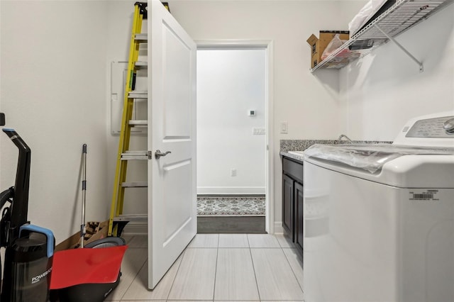 laundry area featuring laundry area, light tile patterned floors, baseboards, and washer and dryer