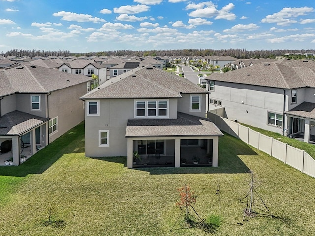 back of property featuring a lawn, a fenced backyard, a residential view, roof with shingles, and stucco siding