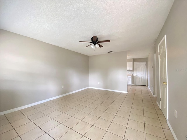 unfurnished room featuring visible vents, baseboards, light tile patterned flooring, ceiling fan, and a textured ceiling