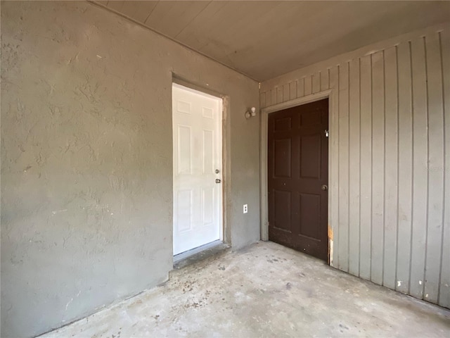 spare room featuring concrete flooring and a textured wall