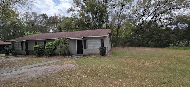 view of front facade with stucco siding and a front lawn