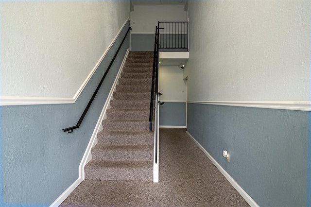 staircase featuring carpet and baseboards