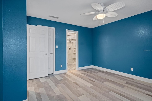 empty room with baseboards, visible vents, ceiling fan, and wood finished floors