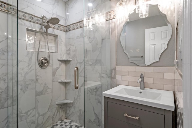 bathroom with a stall shower, tile walls, and vanity