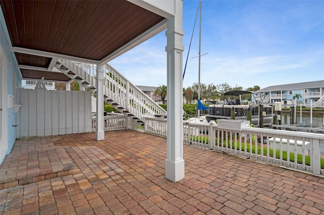 view of patio / terrace featuring stairs, a boat dock, a water view, and boat lift