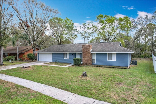 single story home with an attached garage, cooling unit, concrete driveway, and a front yard