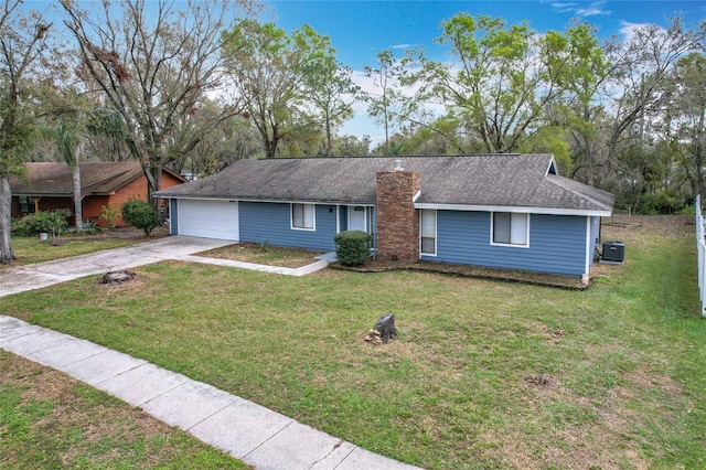 ranch-style home with roof with shingles, a chimney, concrete driveway, an attached garage, and a front lawn