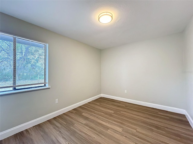 unfurnished room featuring baseboards and wood finished floors