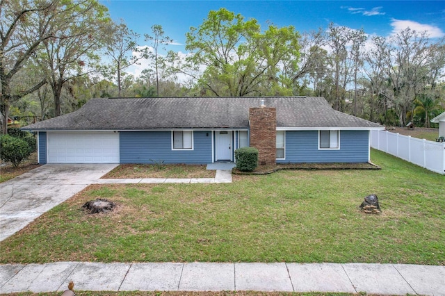 ranch-style house with a chimney, an attached garage, a front yard, fence, and driveway