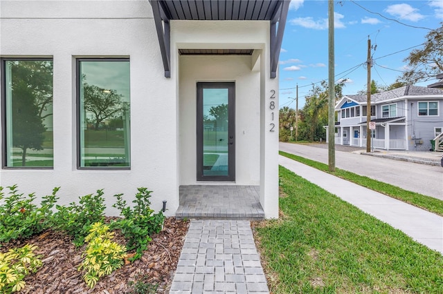 view of exterior entry featuring stucco siding