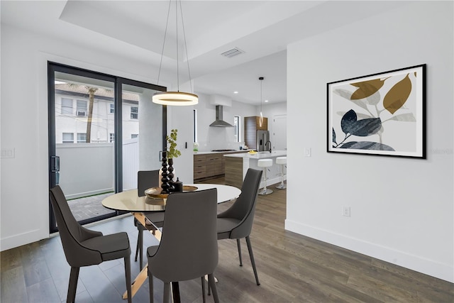 dining area featuring recessed lighting, dark wood-style flooring, visible vents, baseboards, and a tray ceiling