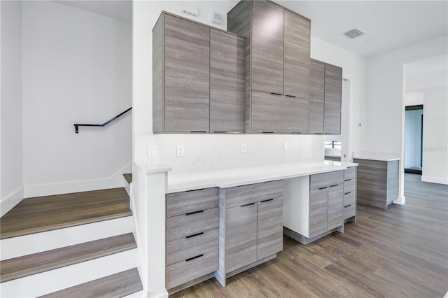 kitchen with visible vents, baseboards, light countertops, dark wood-style floors, and modern cabinets