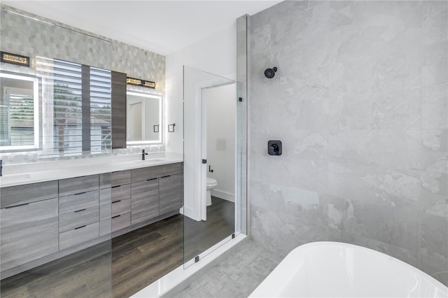 bathroom featuring a walk in shower, a freestanding tub, a sink, tile walls, and double vanity