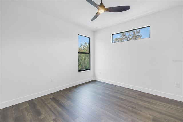 spare room with dark wood finished floors, baseboards, and ceiling fan