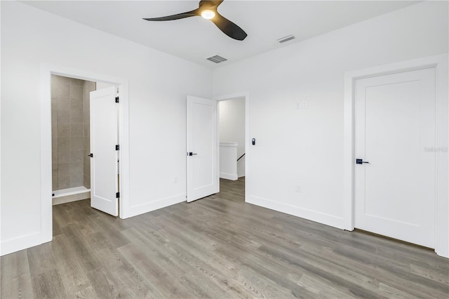 unfurnished bedroom featuring wood finished floors, visible vents, and baseboards