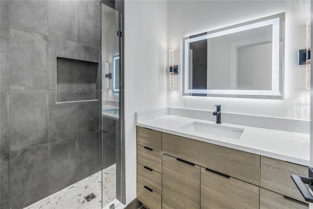 bathroom featuring a tile shower and vanity