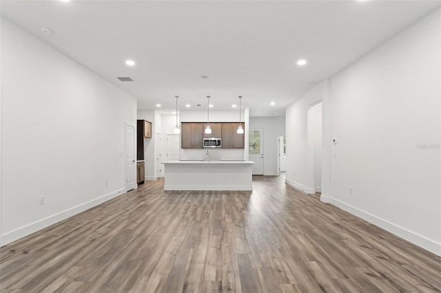 unfurnished living room featuring recessed lighting, visible vents, light wood-style flooring, and baseboards