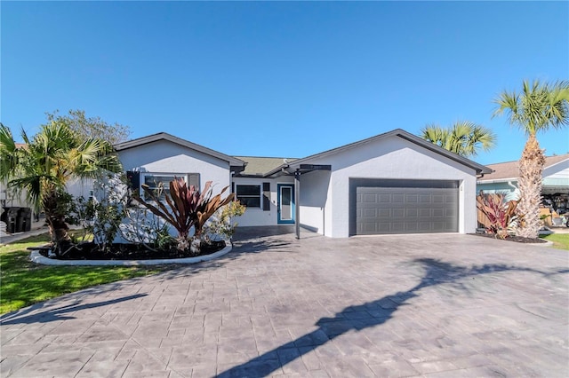 single story home featuring stucco siding, decorative driveway, and a garage