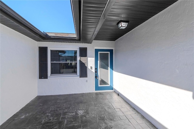 entrance to property with a patio area and stucco siding