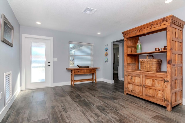 entrance foyer featuring visible vents, dark wood-type flooring, a textured ceiling, recessed lighting, and baseboards