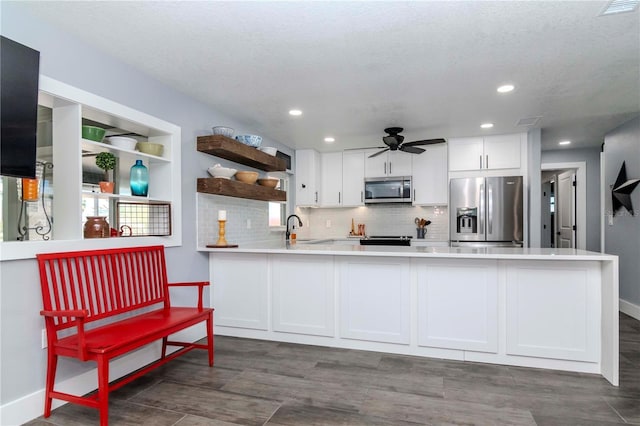 kitchen with open shelves, white cabinets, a peninsula, and stainless steel appliances