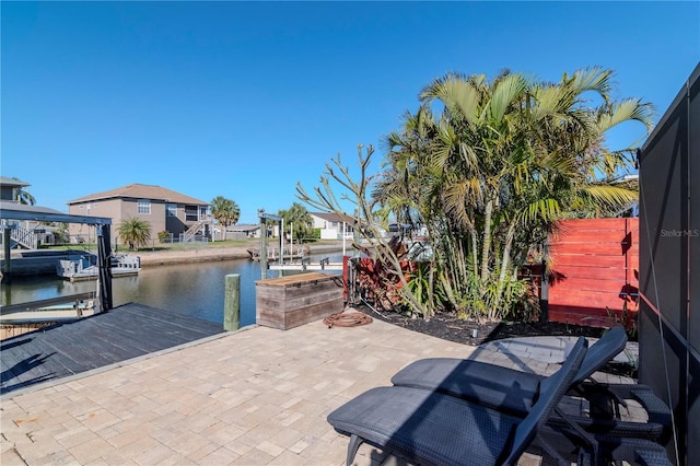 view of patio featuring a water view, boat lift, and a boat dock