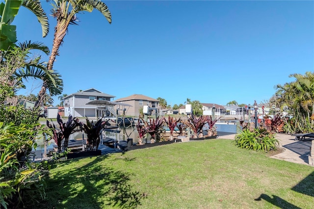 view of yard with a residential view and a boat dock