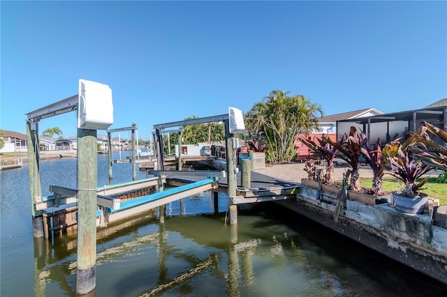 dock area with boat lift and a water view