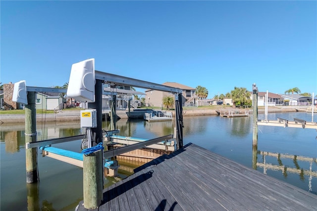 view of dock featuring a residential view, a water view, and boat lift