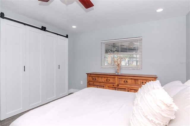 bedroom with recessed lighting, a barn door, and a ceiling fan