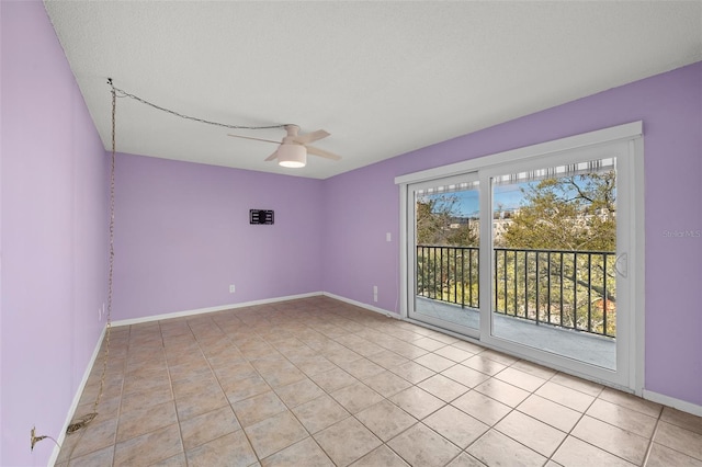 empty room with light tile patterned flooring, ceiling fan, a textured ceiling, and baseboards