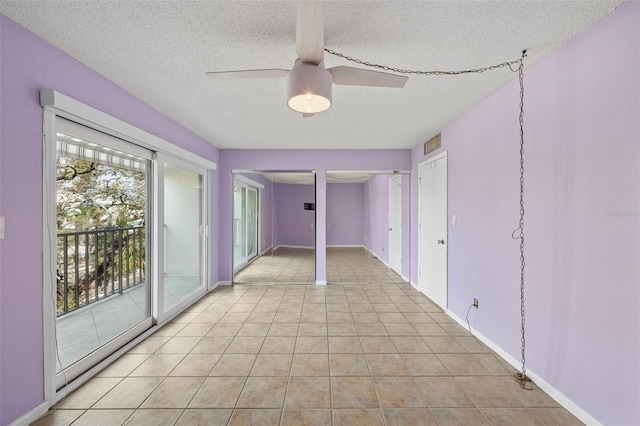 spare room featuring light tile patterned floors, a textured ceiling, visible vents, baseboards, and a ceiling fan