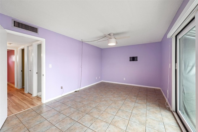 unfurnished room featuring light tile patterned floors, ceiling fan, visible vents, and baseboards