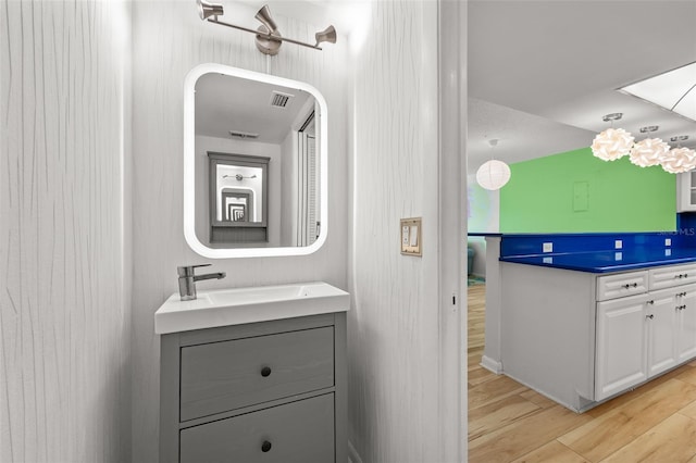 bathroom featuring visible vents, wood finished floors, and vanity