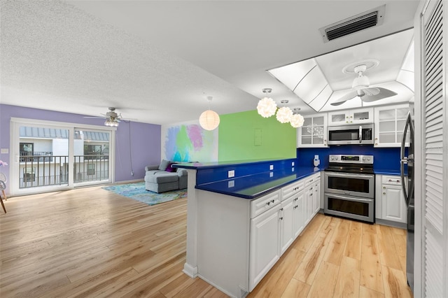 kitchen with appliances with stainless steel finishes, dark countertops, and white cabinets