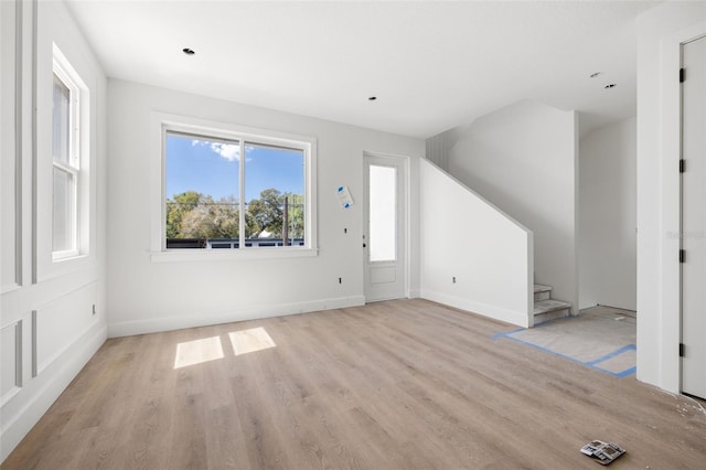 interior space with stairs, light wood finished floors, and baseboards