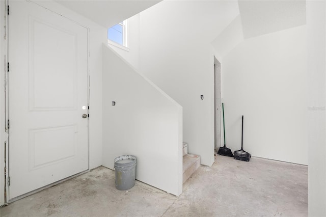 entryway with stairs and unfinished concrete floors