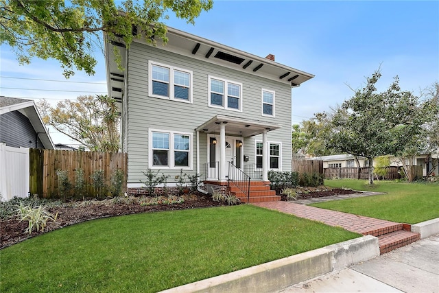 italianate home with a front lawn, a chimney, and fence