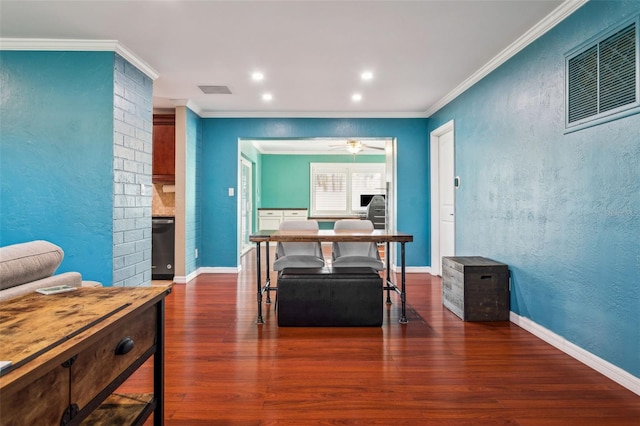 dining space with ornamental molding, wood finished floors, visible vents, and baseboards