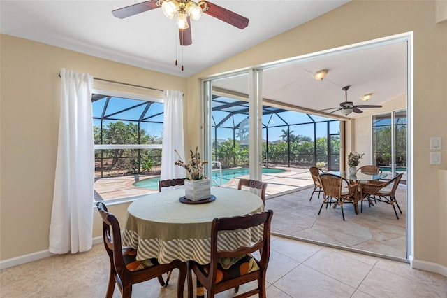 dining space with lofted ceiling, light tile patterned floors, a sunroom, and baseboards