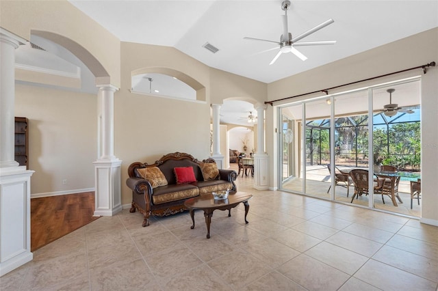 living area with light tile patterned floors, visible vents, lofted ceiling, ceiling fan, and ornate columns