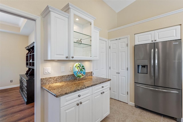 kitchen with dark stone counters, white cabinetry, and stainless steel fridge with ice dispenser